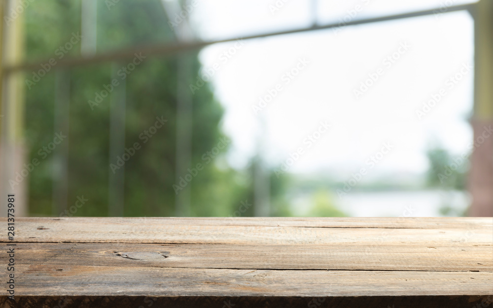Empty of wood table top on blur of curtain with window view green from tree garden background.For montage product display or design key visual layout