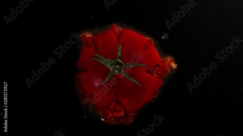 Crush The Raw Tomato With Leaves On A Black Background photo