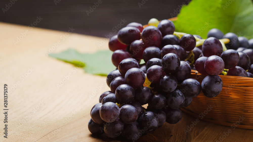 Dark grape in basket on wooden table. Dark grape in basket on wooden table.