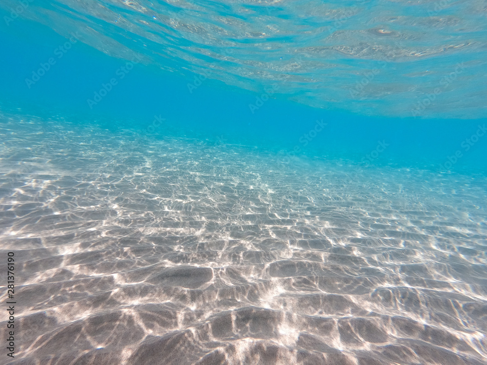Naklejka premium underwater background with sandy sea bottom. Beautiful texture of the sea and ocean water. Pure water texture.