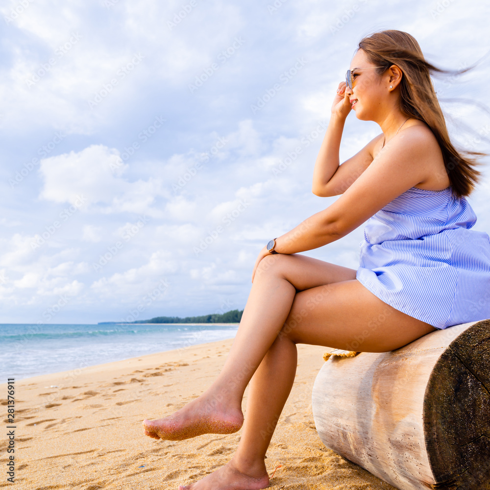 Summer concept of Asian young Woman relaxing on the beach with sunset time in Thailand.Travel concept and summer concept background Summer concept of Asian young Woman relaxing on the beach with sunset time in Thailand.Travel concept and summer concept background