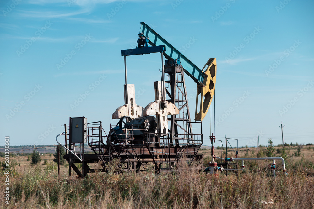 Oil well site pump jack and fields at in rural