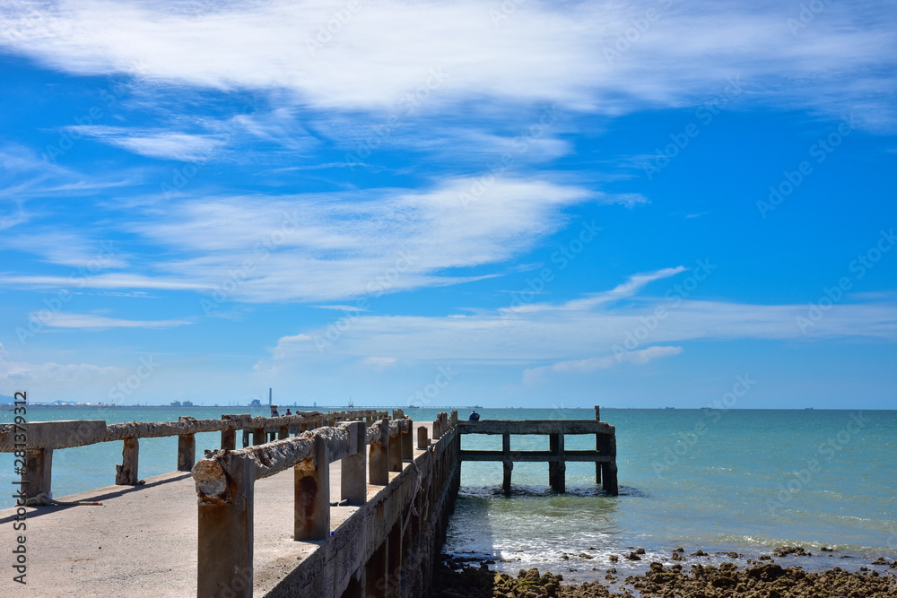 the bridge that stretches out into the sea is made of concrete against blue sky. Located on Pala Beach, Ban Chang, Rayong Thailand.
