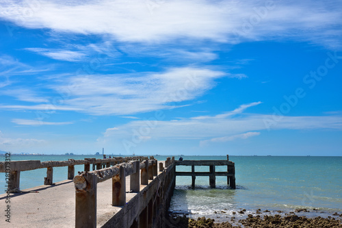the bridge that stretches out into the sea is made of concrete against blue sky. Located on Pala Beach, Ban Chang, Rayong Thailand. © Chaimongkol