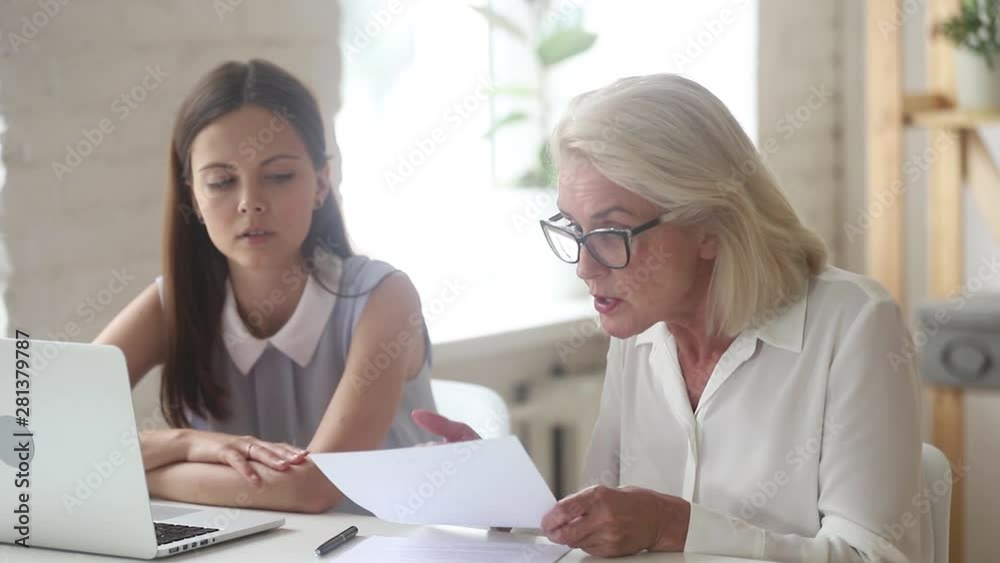 Businesswoman finding error in contract criticizes work of young lawyer Businesswoman finding error in contract criticizes work of young lawyer