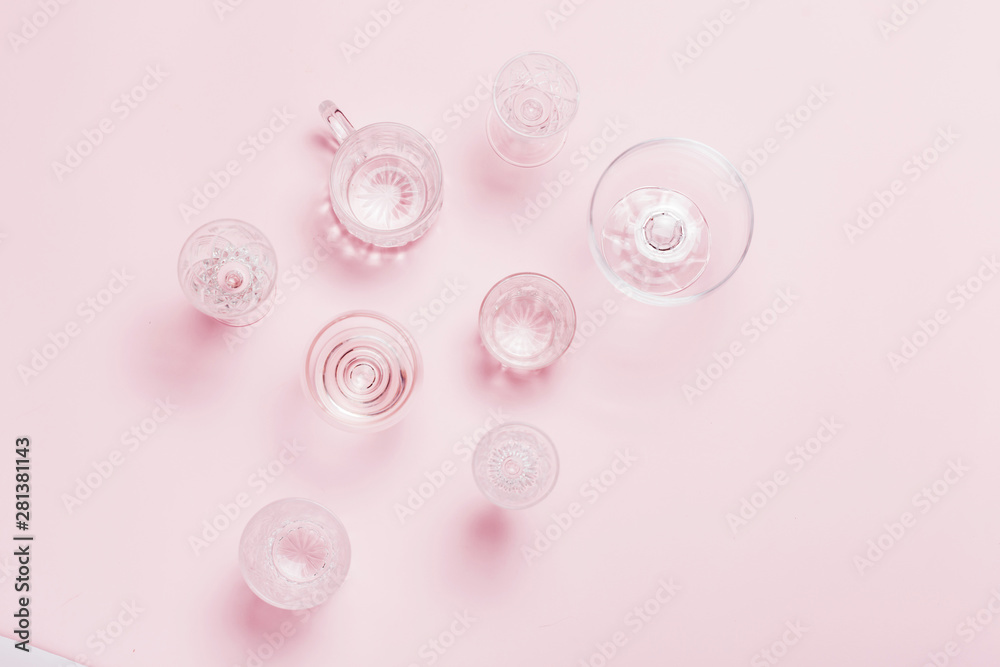 Many empty glasses on pink background. Top view, flat lay. Many empty glasses on pink background. Top view, flat lay.