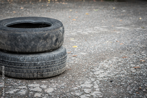 Old dirty car tires on cracked asphalt. Close-up