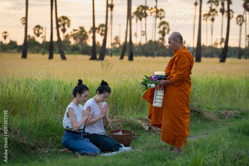 Women make merit with monk in rural areas according to the beliefs of Buddhism in Thailand photo