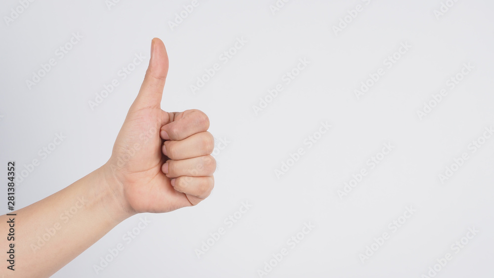 Male's left hand doing thumbs up sign on white background.