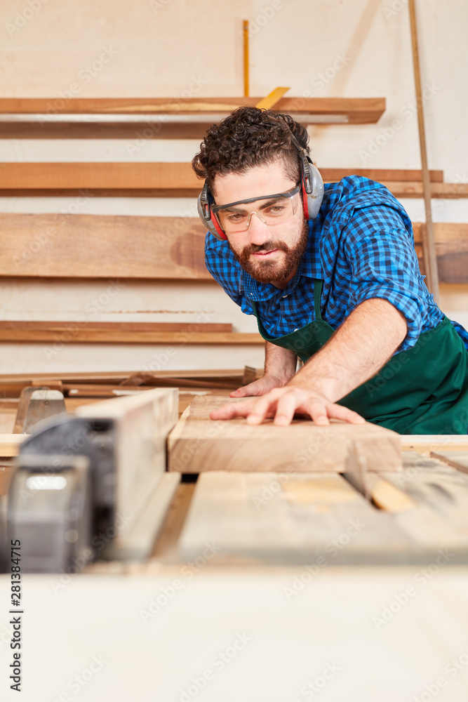 Joiner sawing the wood on the circular saw