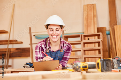 Carpenter apprentice with checklist in the workshop