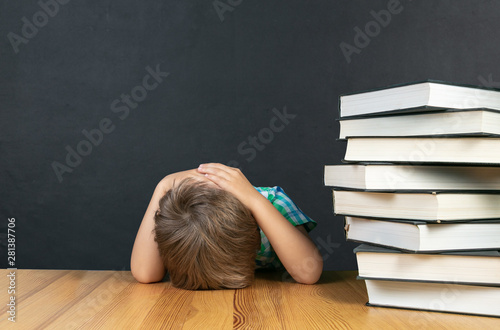 Back to schhol concept - depressed boy in front of blackboard, copy space photo