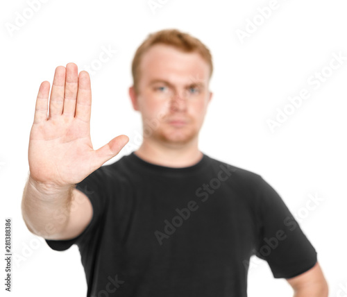 Man in black t-shirt with blurred face with a gesture of stop isolated white background