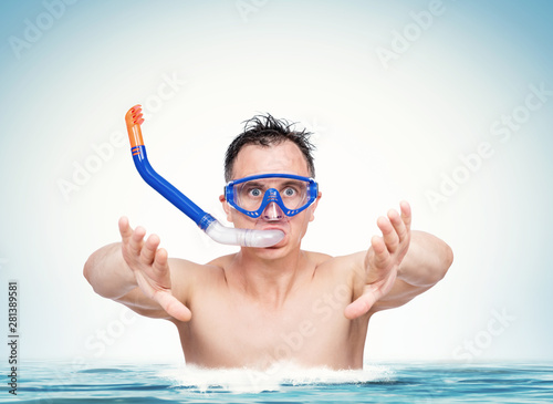 Happy funny man in a swimming mask with snorkel is preparing to dive into the water. Sea holiday concept.