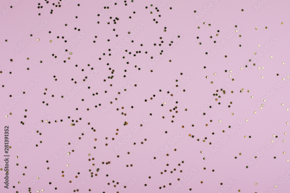 Golden sparkles stars on pink pastel trendy background. Festive background. Flat lay, top view
