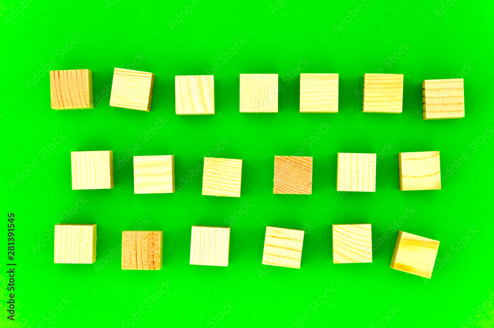wooden cubes on green background, three rows of wooden cubes for your advertising slogan on green background