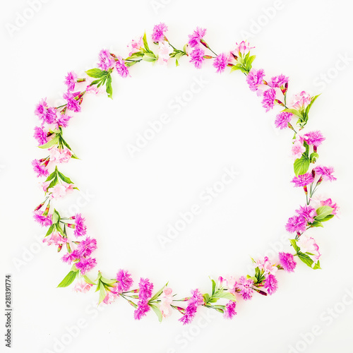 Round frame of pink flowers on white background. Flat lay  Top view