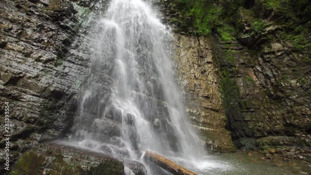 Mountain waterfall PAN with fallen tree trunk and green trees on the top (4K, 25fps) Mountain waterfall PAN with fallen tree trunk and green trees on the top (4K, 25fps)