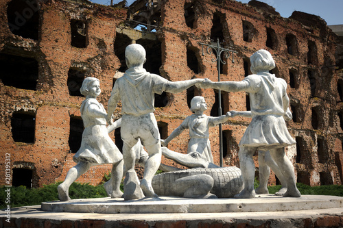 Volgograd/Russia-18.06.2016:The statue of with circle of kids and crocodile and destroyed building photo