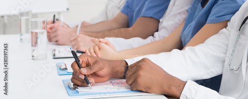 Medical education. African-american doctor writing notes closeup © Prostock-studio