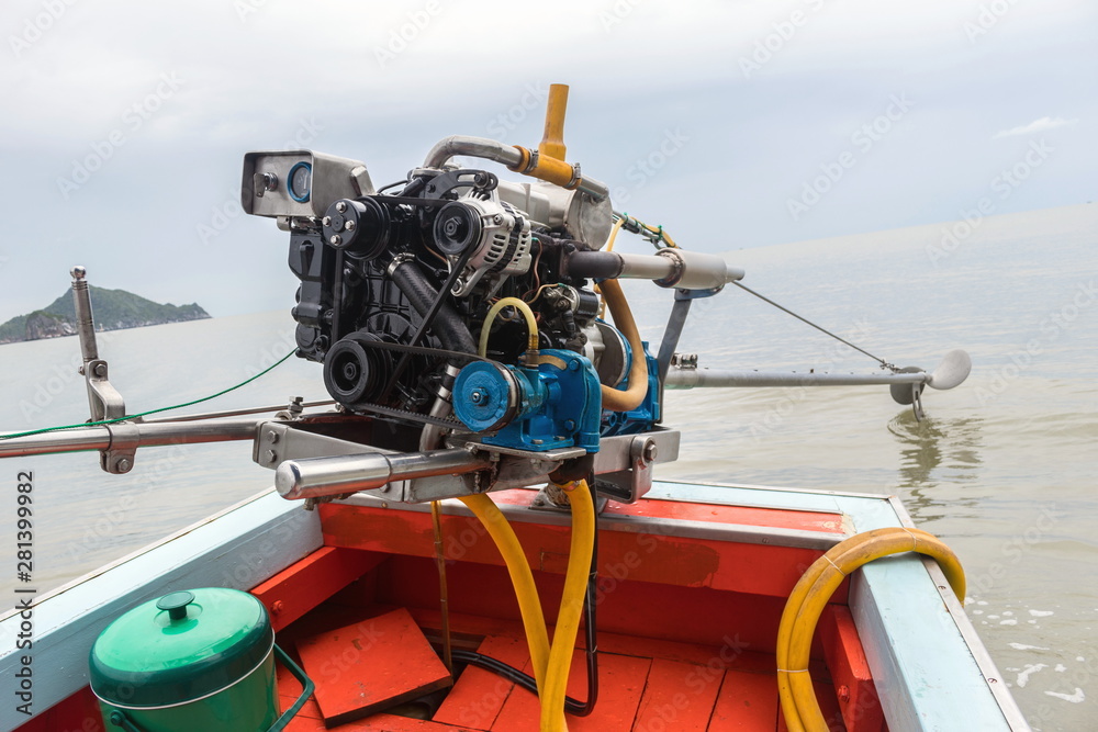 The diesel engine with accelerator and propeller of the small wooden fishing boat is parked on the sea