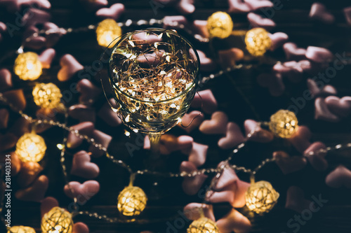 Lights in the wine glass. Hearts on background. Romantic love concept. Festive ideas. Valentines day postcard.