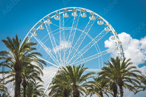 White ferris wheel cabin with blue sky in sunny day. Romantic amusement park toy