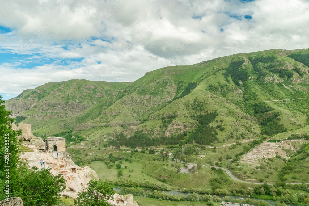 Panoramic view of Vardzia cave monastery town. View from the monastery to the river valley and green slopes on a sunny summer day