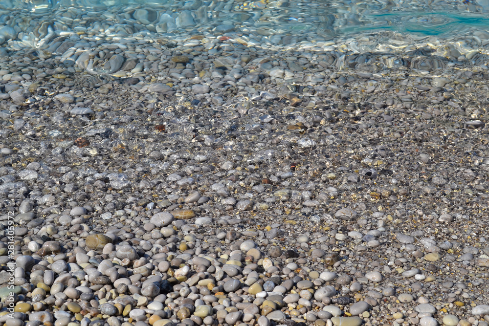 Sea wave moves to a pebble beach. Summer sunny day. View from above Sea wave moves to a pebble beach. Summer sunny day. View from above