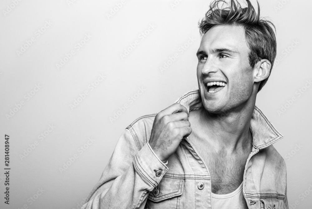 Fototapeta premium Handsome young man in jeans jacket. Black-white studio portrait.