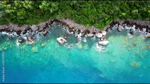 Aerial video from above of beautiful coastline and ocean waves near the tropical island beach. Holiday and vacation concept.