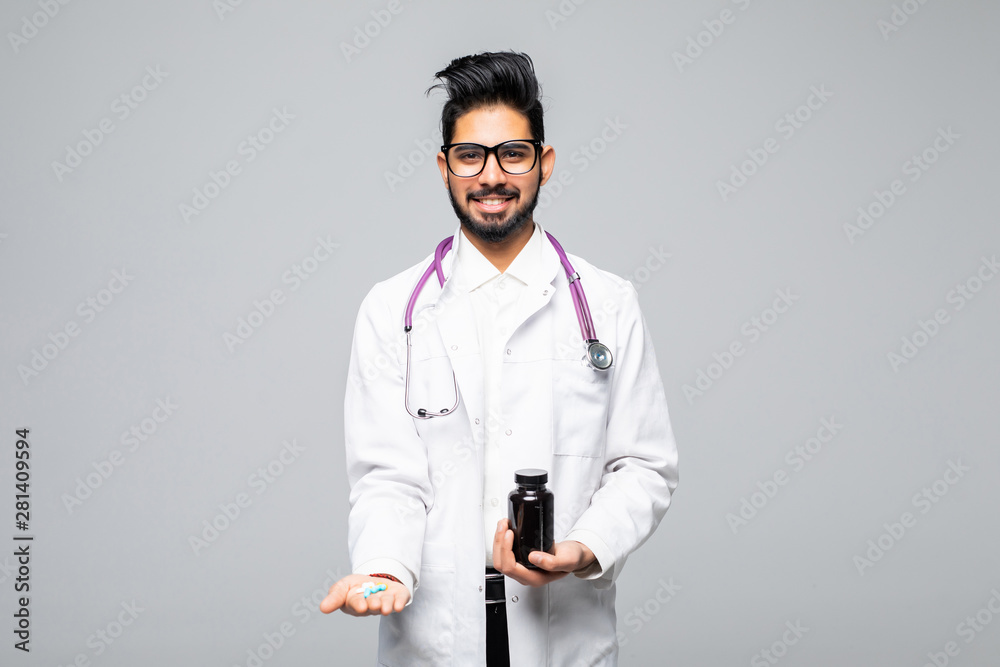 Handsome indian male doctor holding empty white or blank dropper bottle standing isolated over white background Handsome indian male doctor holding empty white or blank dropper bottle standing isolated over white background