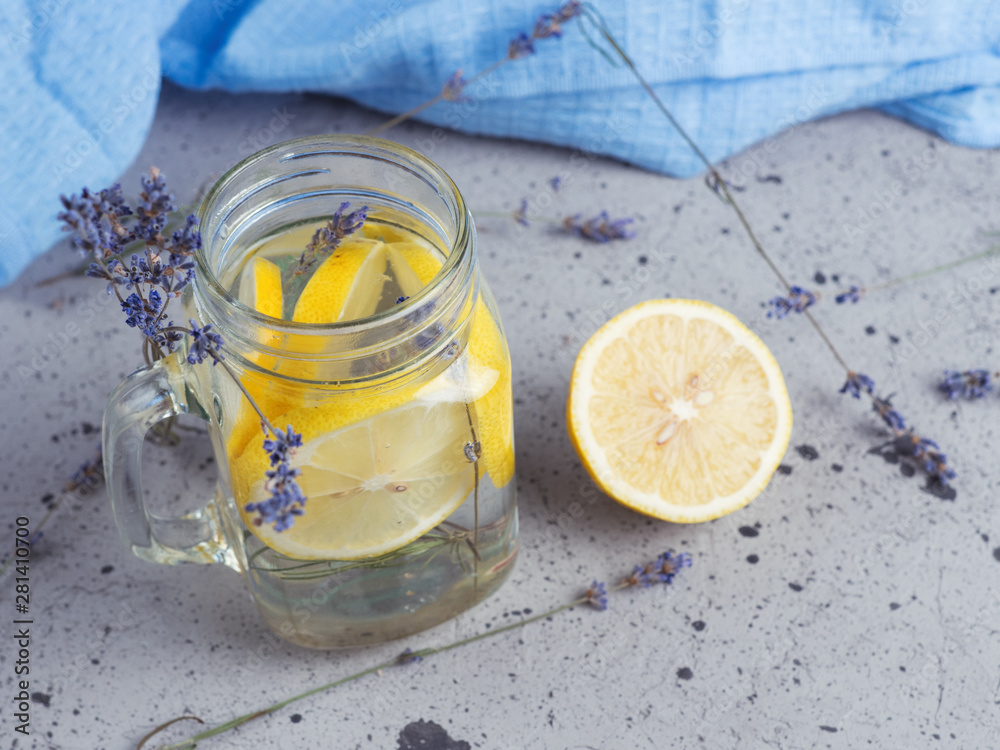 Lavender water with lemon in a jar on a blue background Lavender water with lemon in a jar on a blue background