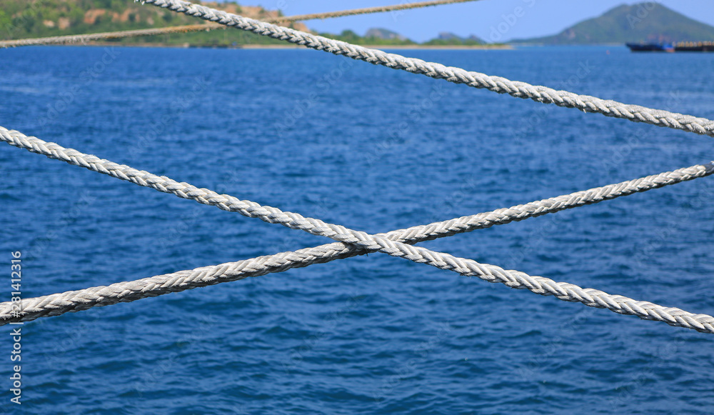 Ship rope against blue water sea texture background.