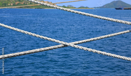 Ship rope against blue water sea texture background.