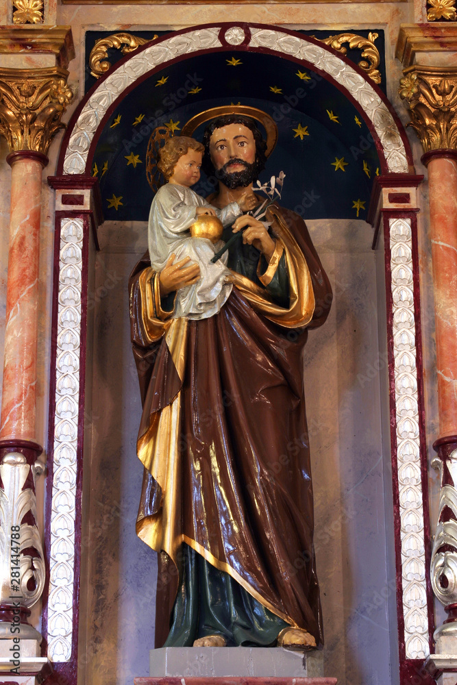 Fototapeta premium Saint Joseph holding baby Jesus, statue on the altar of Saint Joseph in the Church of Saint Barbara in Rude, Croatia