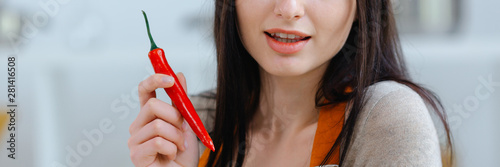 Beautiful woman holding red chili pepper