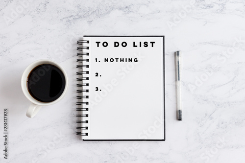 To do list nothing writing on notebook. Notebook on desk with coffee cup and a pen. photo