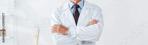 cropped view of doctor in white coat standing with crossed arms