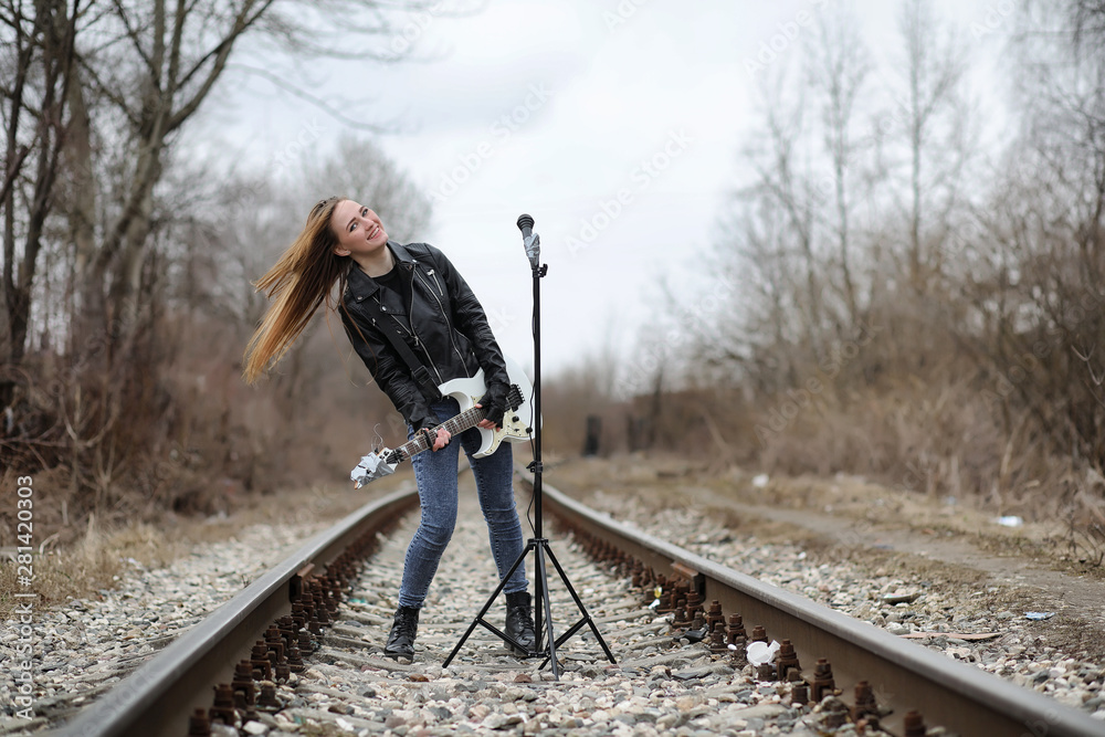 A rock musician girl in a leather jacket with a guitar A rock musician girl in a leather jacket with a guitar
