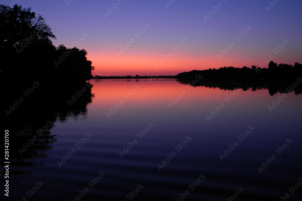 Beautiful sunset by the river.The sky is reflected in the water