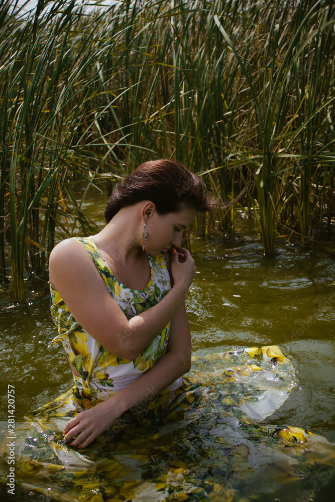 Fototapeta premium young woman in the water in dress