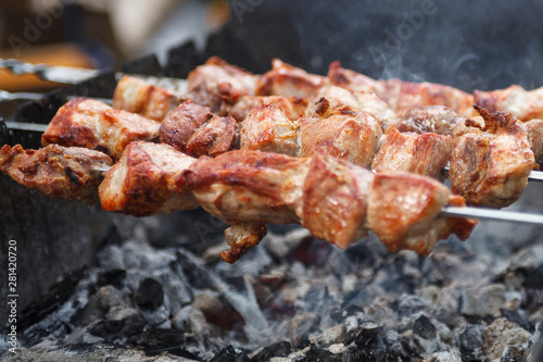 Close up selective focus fresh hot delicious bbq kebab grilling on open grill, food festival, outdoor kitchen, roasting on skewers, summer picnic, food-court