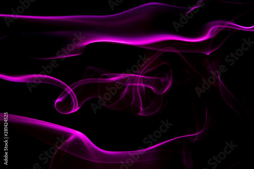 Abstrakcyjne tło z kolorowymi formami symbolizującymi przepływ energii. Kolorowy dym na czarnym tle.