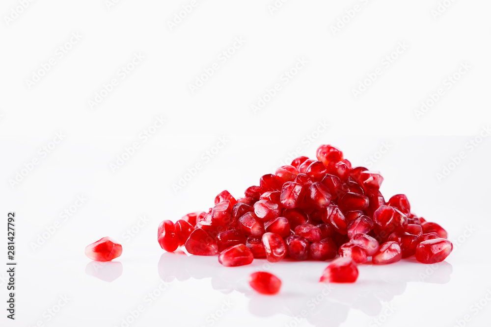 Pomegranate fruit with seeds on a white background. A glass of pomegranate juice Pomegranate fruit with seeds on a white background. A glass of pomegranate juice
