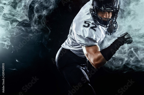 American football sportsman player in helmet on black background with smoke. Sport and motivation wallpaper.
