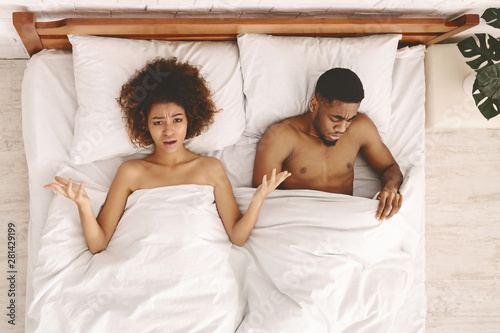 Foto Upset pair of lovers lying on the bed. Family conflict.