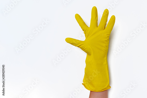 Hand with yellow cleaning gloves showing symbolic gestures. hand in a yellow protective glove counts up to five