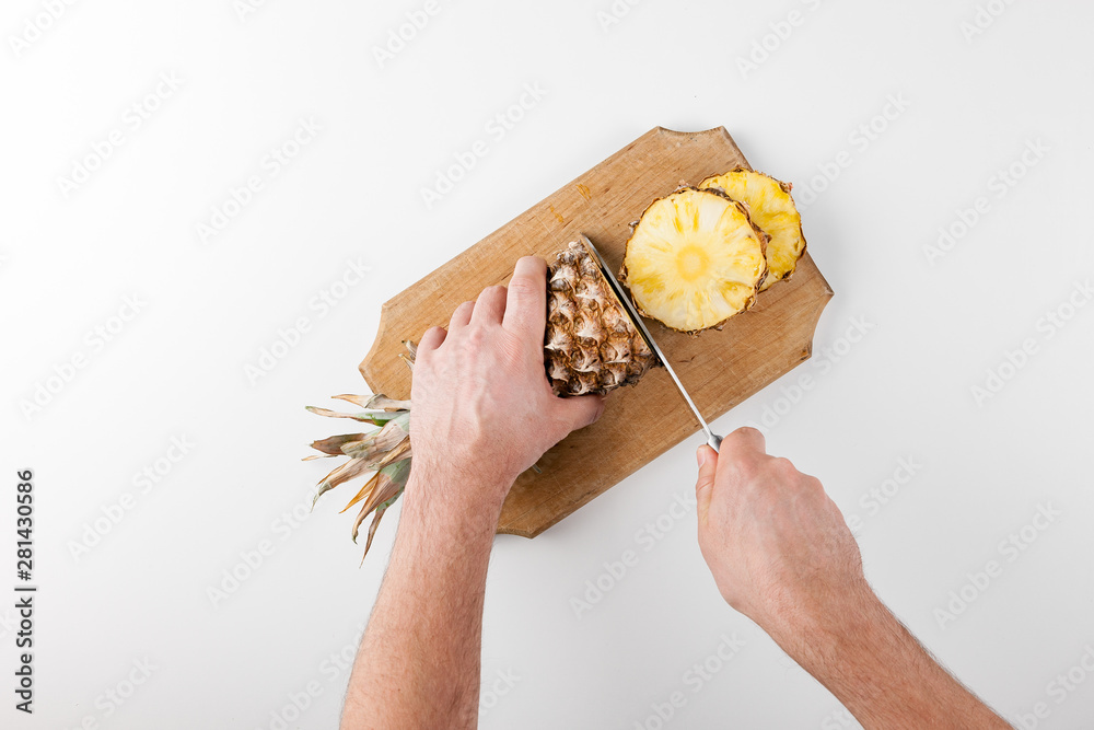 Pineapple fruit on a white background. Pineapple on the kitchen board with a knife slices