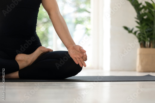 Closeup woman sit in lotus pose folded fingers mudra gesture